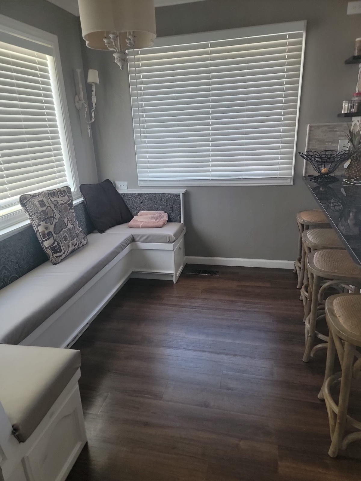 A cushioned corner bench under two windows in the kitchen.