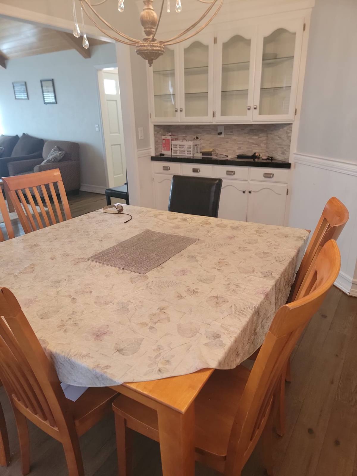 The dining table beside a built-in cabinet with glass-fronted shelves.