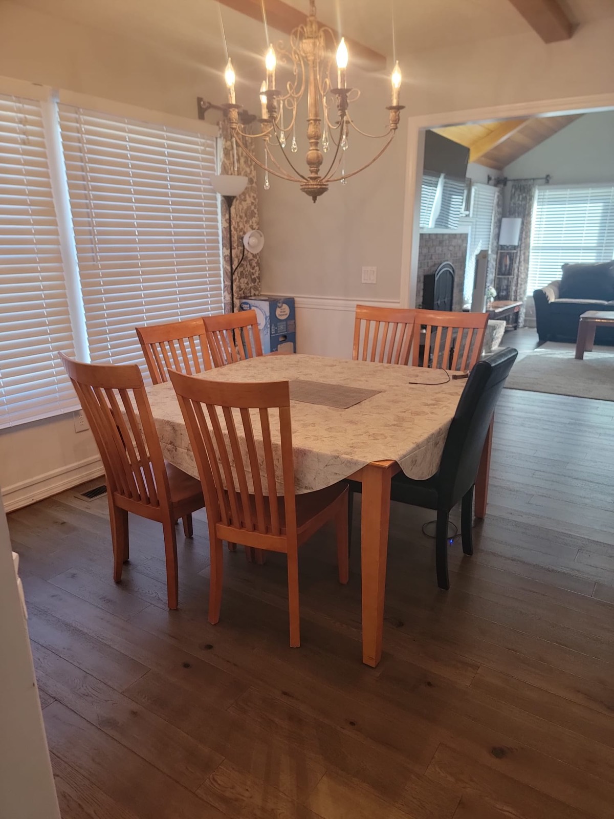The dining room: a table and chairs under a chandelier, opening onto the living room.